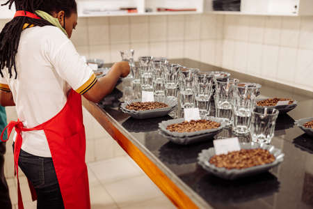 African American woman putting notes on plates with coffee for tastingの写真素材