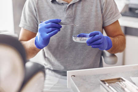 dentist is taking a drill in modern light stamotology clinicの写真素材