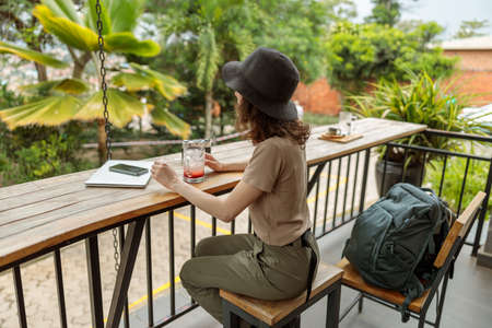 Young female tourist enjoying cool drink in cafe outdoors