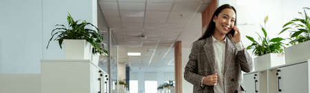 Asian business woman making a phone call and smiling at office