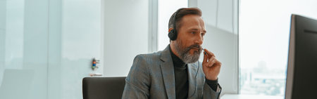 Male entrepreneur is busy while speaking onlineの写真素材