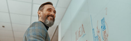 Smiling Caucasian man using whiteboard for his presentationの写真素材