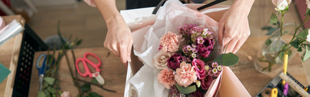 Professional florist young woman is doing bouquets at flower shopの写真素材