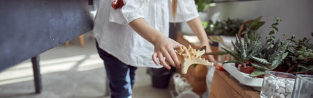 Hands of young caucasian girl who is working to do a composition.Flourist shop with different kinds of dryed flowersの写真素材