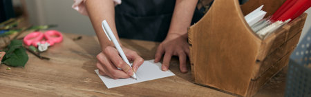 Professional florist young woman is doing bouquets at flower shopの写真素材