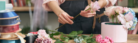Professional florist young woman is doing bouquets at flower shopの写真素材