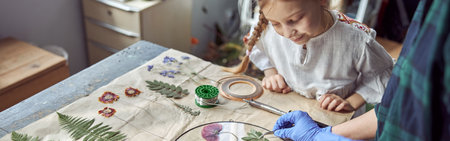 Flourist shop with different kinds of dryed flowers. Young happy confident specialist is working with her female kid.の写真素材