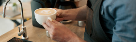 Barista hands holding white cup of coffeeの写真素材