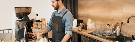 Handsome barista grinds coffee beans in coffeemachineの写真素材