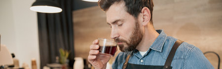 Handsome barista with stylish beard smelling filter coffee in cafeteriaの写真素材
