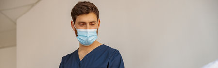 Doctor in mask writing medicine recomendation to patient in hospital ward during Covid-19 epidemic