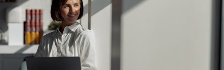 Attractive european business woman in casual clothe with laptop standing in modern office