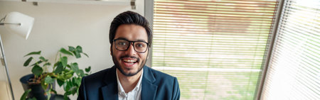 Smiling businessman in suit working with documents from home office and looking at camera