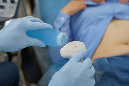 Close up of doctor hands applying gel on ultrasound device before treatment