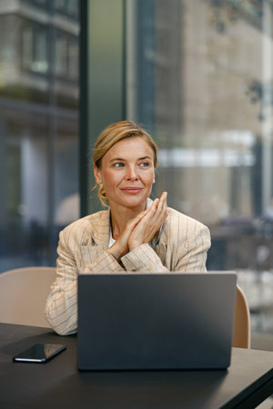 Stylish business woman sitting in modern coworking and working on laptop. High quality photoの写真素材