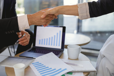 Close up of business people shaking hands after concluding deal in office meeting room