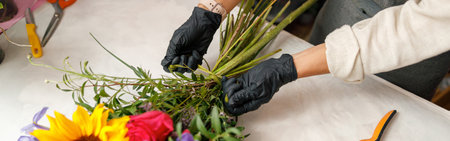 Close up of gardeners in the flower shop make bouquet for a holiday. Family flowers businessの写真素材