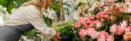 Smiling woman florist small business owner standing in own floral store and waiting for clientの写真素材