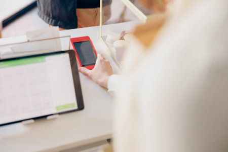 Close up of barista holds out a terminal for contactless paying to a client in coffee shop