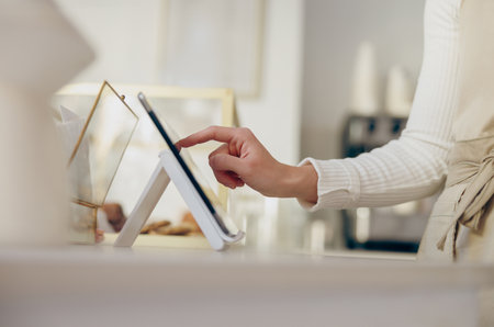 Close up of barista standing at the counter in coffee shop and takes orders from client