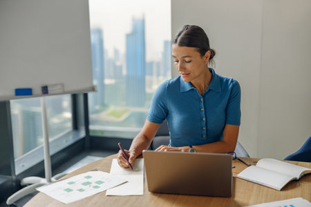 A dedicated business professional is diligently working on a laptop in a modern office space