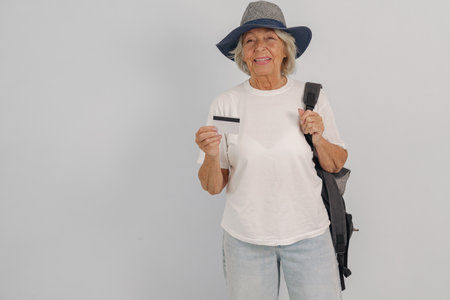An active senior woman joyfully travels with her packed backpack