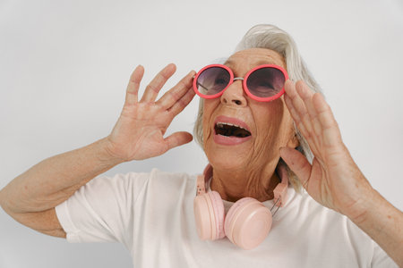 A Joyful Elderly Woman Wearing Sunglasses and Headphones Radiates Happiness and Energy