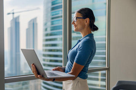 A Professional Woman Engaged in Work on Her Laptop Within a Stylish Modern Office Environmentの写真素材