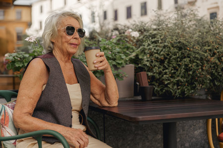 An Elegant Elderly Woman is Enjoying Her Coffee in a Delightful Outdoor Setting Todayの写真素材