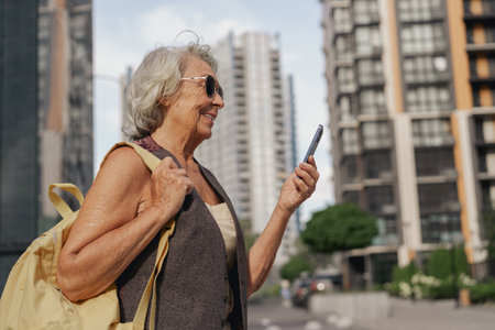 Senior woman enjoys city life while using her smartphone to stay connected with loved ones