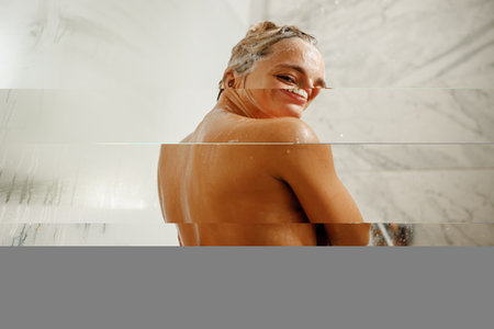 An Exuberant Joyful Shower Moment Captured Beautifully in a Contemporary Bathroom Settingの写真素材