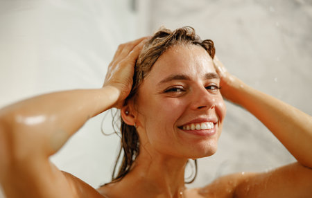 A Joyful Woman Absolutely Enjoying a Refreshing Shower Moment in her beautiful bathroomの写真素材