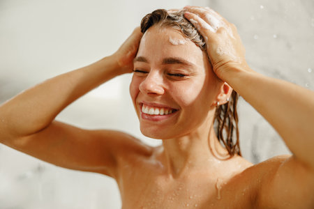 A joyful woman enjoys a refreshing shower with lathered hair, embracing blissful moments