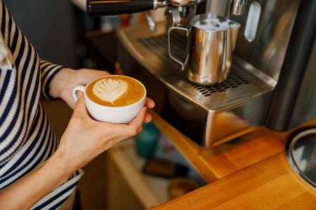 Barista Preparing Beautiful Latte Art in a Cozy Cafの写真素材