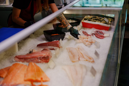 Fresh Seafood Display at a busy market featuring various fish and shellfish ready for selectionの写真素材