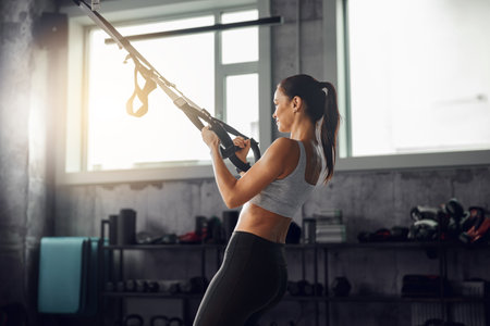Fitness enthusiast using training in a gym to enhance performance, strength, and wellbeingの写真素材