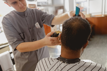 A Professional Barber Skillfully Styling a Clients Hair Inside a Contemporary Salon Settingの写真素材