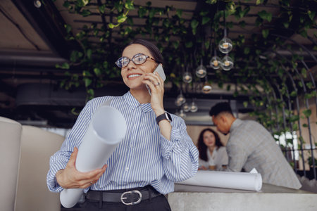 A professional woman engaging in a detailed discussion about future plans in a modern office spaceの写真素材