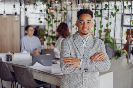 A Confident Professional Flourishing in a Modern Office Environment with Team Collaborationの写真素材