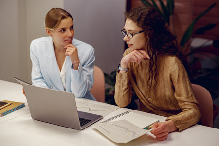 A Business Meeting Taking Place Between Two Professional Women in a Modern Office Environment