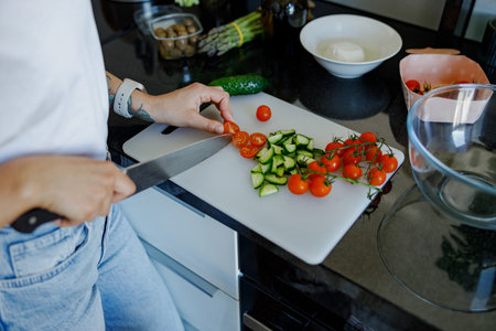 Carefully preparing fresh vegetables in a modern kitchen for a delightful cooking experienceの写真素材