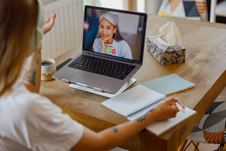 Enjoying a Virtual Meeting with Friends on a Laptop While Sipping Coffee Together