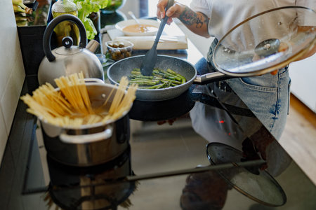 Enjoying Delicious Home Cooking The Art of Preparing Pasta and Fresh Vegetablesの写真素材