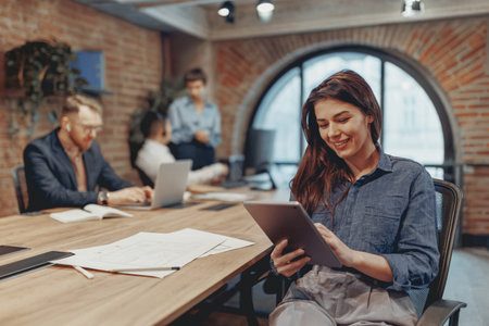 Engaging Collaborative Team Meeting While Utilizing Modern Workspace and Digital Devicesの写真素材