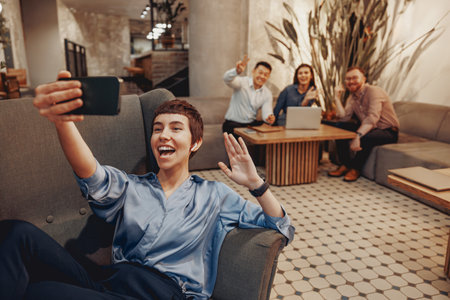 Capture a Group Selfie Moment in a Modern Workspace Setting Filled with Happiness and Funの写真素材