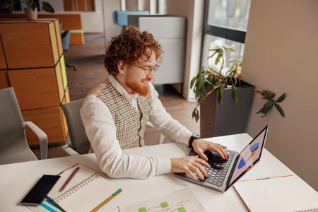 A Creative Professional is Engaged with Their Laptop in a Stylish and Modern Office Space