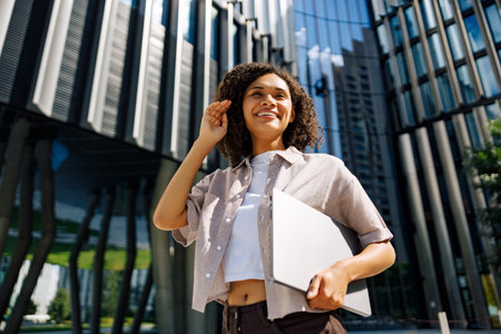 A Confident Professional Woman Engaged in Work Outdoors in a Vibrant Urban Settingの写真素材