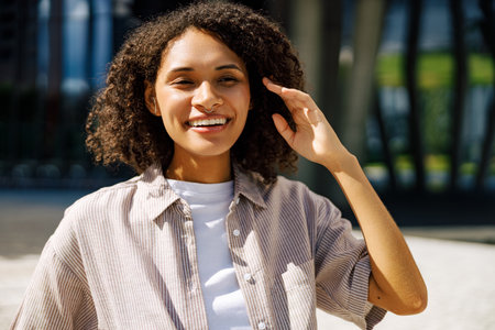 A Joyful Young Woman is Brightly Smiling in a Modern Urban Setting Surrounded by Nature
