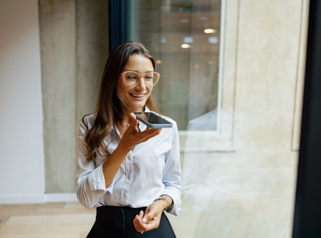 A professional woman utilizing a voice assistant in a modern and contemporary office setting