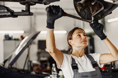 A skilled mechanic works on a vehicle in a garage, ensuring quality repairs and maintenanceの写真素材